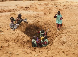 In Laresoro, Kenia, graben die Dorfbewohner Lcher, um Wasser zu finden. Hier halten Kinder auf dem Weg zur Schule an, um zu trinken und ihre Flaschen aufzufllen, obwohl das Wasser verschmutzt und voller Bakterien ist. (c) Cyril Zannettacci